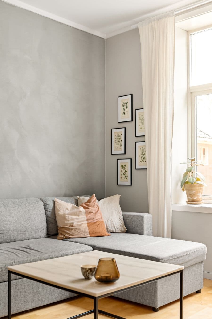 Modern minimalist living room with grey sofa and large window